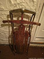 Front view of sled showing metal handle shield, wooden slats and runners