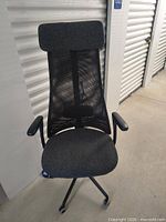 Front view showing fabric seat, mesh backrest, headrest, armrests and wheeled base