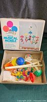 Box front and contents of Walt Disney Musical Mobile set