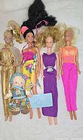 Group shot of four fashion dolls and rag doll