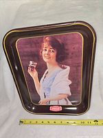 Front of metal Coca-Cola tray with artwork and logo