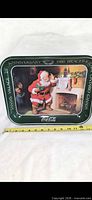Front of 1980 Santa’s Village Coca-Cola anniversary tray with measuring tape for scale