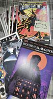Stack of assorted comic books showing covers of The Omega Men, House of Slaughter and others