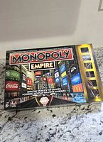 Front of Monopoly Empire box showing branding and age rating