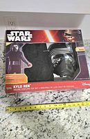 Front of boxed Kylo Ren costume set with tape measure for scale