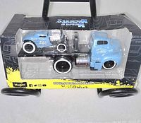 Front view of boxed Muscle Machines die-cast set showing both vehicles