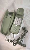Front view of green Western Electric Trimline phone showing handset, keypad, cradle and cord