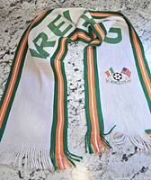Full scarf laid out showing stripes, lettering, crest, fringe