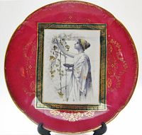Front view showing full plate design, red rim, gold detailing, central scene