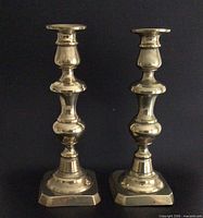 Front view of both brass candlesticks standing upright