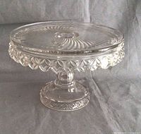 Overall view of clear pressed glass cake stand on pedestal base