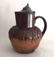 Full view of jug showing stoneware body, handle and pewter lid