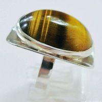 Oblique view showing tiger eye cabochon and concave bezel