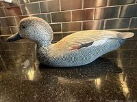 Left side view of carved wooden duck decoy