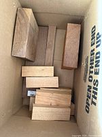 Box containing multiple rectangular hardwood blanks in varying tones