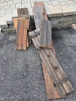 Pile of assorted long and short barn wood boards on pavement