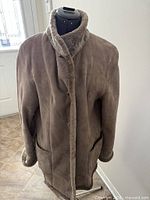 Front view of taupe sheepskin coat on mannequin
