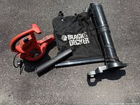 all components laid out: blower unit, collection bag, large tube, nozzle