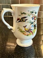 Front view showing bird design and gold rim