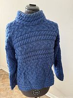 Front view of medium blue fisher knit sweater on mannequin