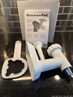 kit components laid out: grinder body, pusher-wrench, stuffer tube, instruction manual, box
