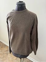Front view of beige cashmere sweater on mannequin