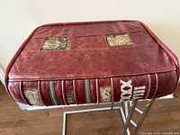 Top view showing burgundy leather cover with gold patterned insets and simulated book spine