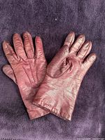pair of burgundy leather gloves front view