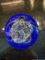 Top view showing internal white bubble inclusions and three dimples