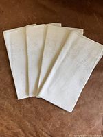 Four folded napkins laid out showing overall condition