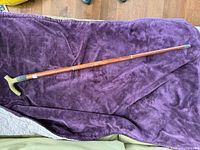 Full view of cane on purple fabric showing length and overall condition