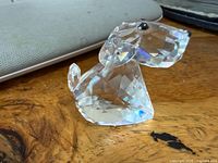 Front three-quarter view of clear crystal dog figurine on wood surface