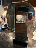Front view of male profile mirror mounted in black acrylic base