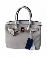 Front view of satchel showing cream body, croc flap, handles, tag, padlock, smiley swatch