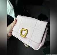 Front view of light pink Songmont Chocolate bag showing buckle and leather texture