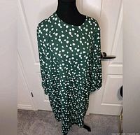 Front view of green spotted dress on mannequin