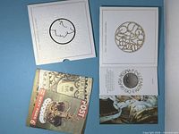 Outer and inner Royal Mint presentation booklet covers with coin recess visible