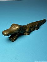 Full view of brass alligator opener, mouth open