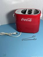 Front view of Coca-Cola hot dog toaster with power cord and tongs