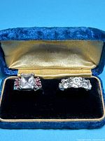 Both sterling silver rings displayed in open blue velvet case
