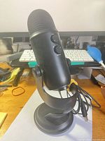 Side view of black Blue Yeti microphone on stand with USB cable attached