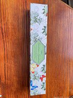 Closed box showing floral design and butterflies