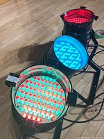 Three LED Par cans lit in different colours on floor stands