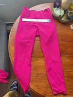 Full view of hot-pink leggings laid flat on table