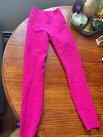Full view of magenta leggings front side on table
