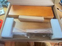 Box opened showing wood knife block parts cushioned by foam and plastic