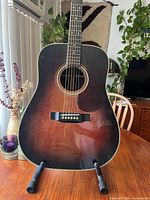 Front of sunburst Sigma SDR-28S guitar on stand