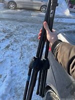 Both folded microphone stands held together outdoors