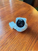 Front view of Wyze Cam v4 showing lens and included power adapter