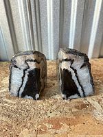 Front view of the two polished black agate halves showing banding